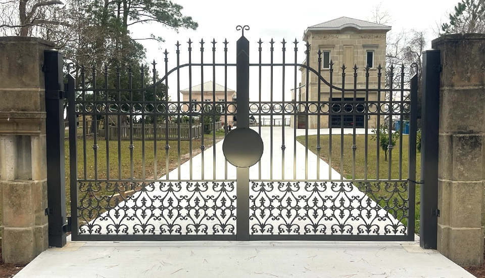 Iron driveway fence in front of house on the water